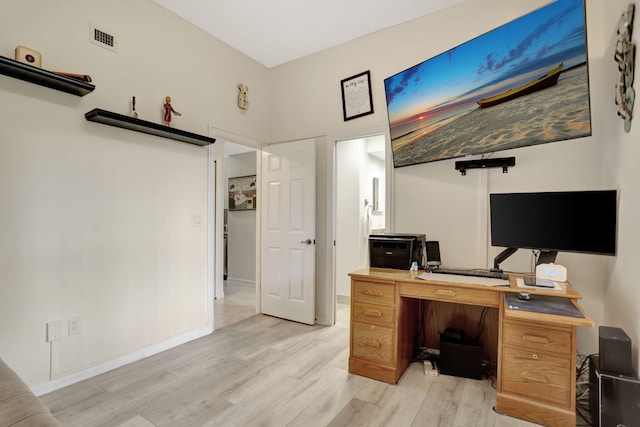 home office with light hardwood / wood-style flooring