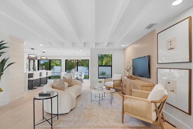 living room with beamed ceiling and light wood-type flooring