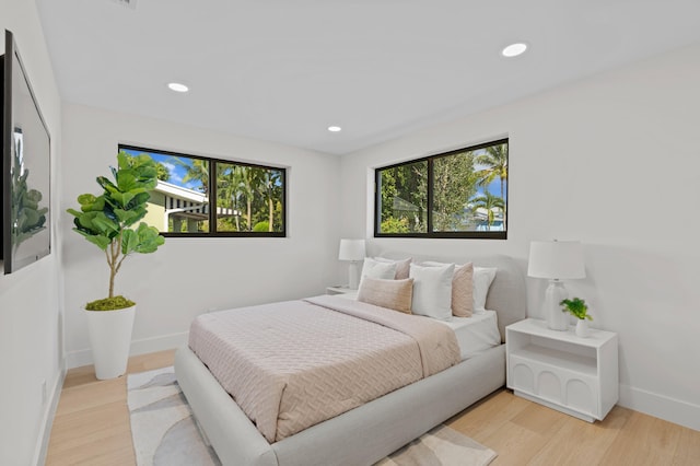 bedroom featuring light hardwood / wood-style flooring and multiple windows