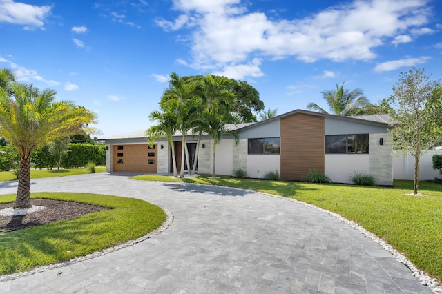 single story home featuring a garage and a front lawn