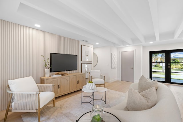 living room featuring light hardwood / wood-style floors, beam ceiling, and french doors