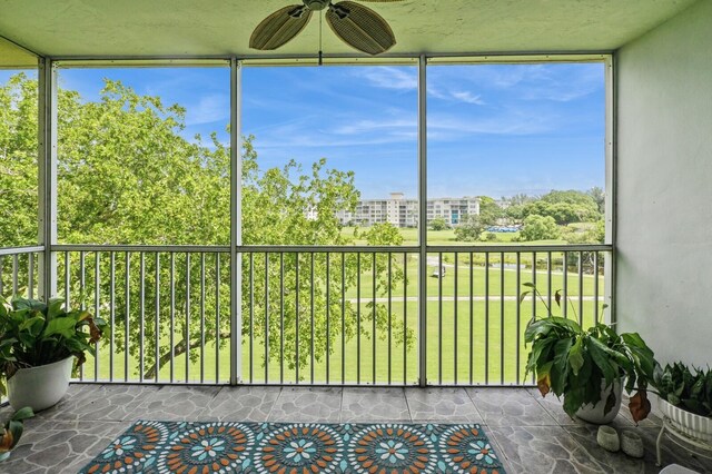 unfurnished sunroom featuring ceiling fan