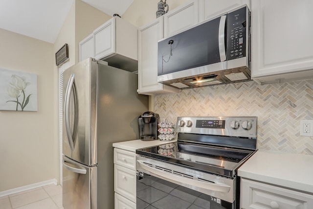 kitchen with stainless steel appliances, lofted ceiling, white cabinets, and backsplash