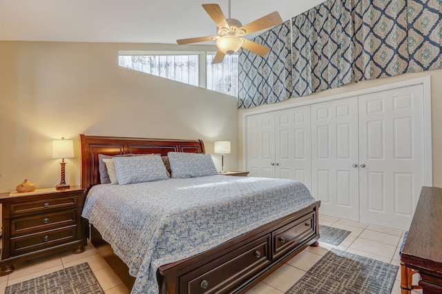 bedroom featuring a closet, lofted ceiling, ceiling fan, and light tile patterned flooring