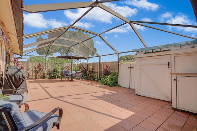 view of patio with glass enclosure and a shed