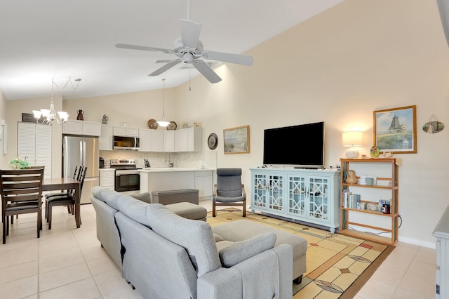 tiled living room featuring ceiling fan with notable chandelier, sink, and high vaulted ceiling