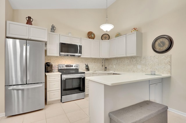 kitchen featuring appliances with stainless steel finishes, hanging light fixtures, a kitchen breakfast bar, tasteful backsplash, and white cabinets