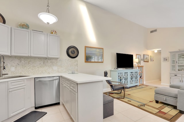 kitchen featuring white cabinets, pendant lighting, lofted ceiling, kitchen peninsula, and dishwasher