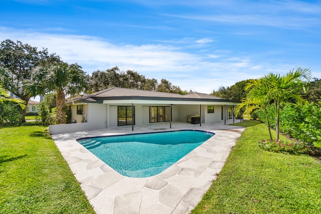 view of pool with a patio and a yard