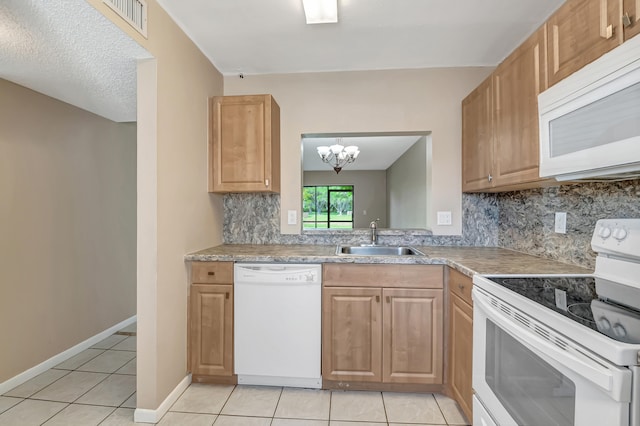 kitchen with backsplash, light tile patterned floors, white appliances, a chandelier, and sink