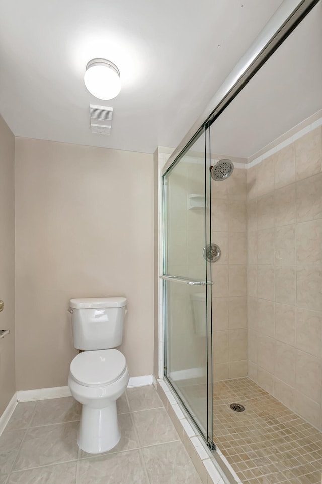 bathroom with toilet, a shower with door, and tile patterned floors