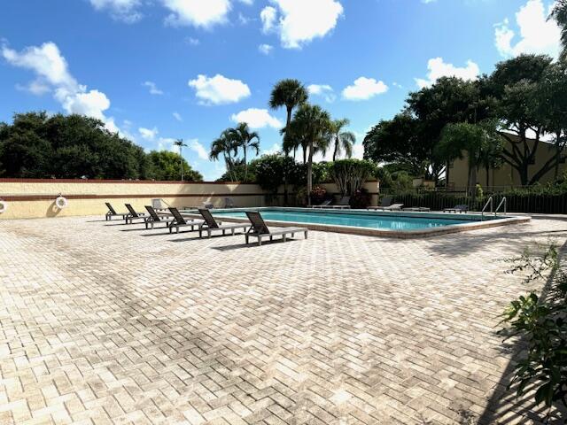 pool with fence and a patio