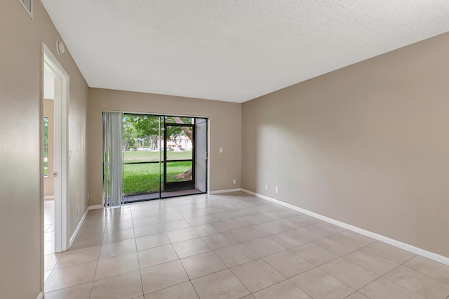 unfurnished room with light tile patterned floors, visible vents, baseboards, and a textured ceiling