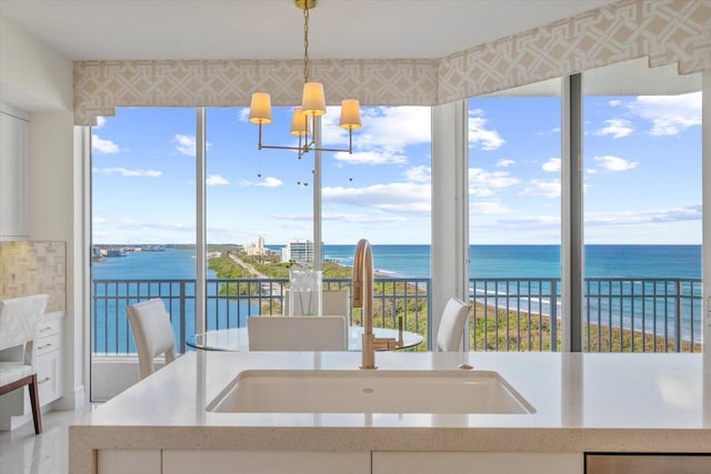 interior space with an inviting chandelier, sink, and a water view