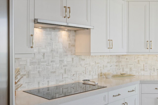 kitchen featuring black electric cooktop, decorative backsplash, and white cabinets