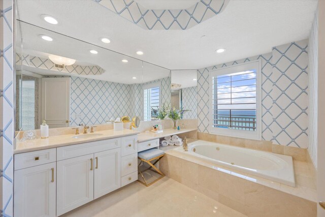 bathroom featuring vanity, a wealth of natural light, and tiled bath