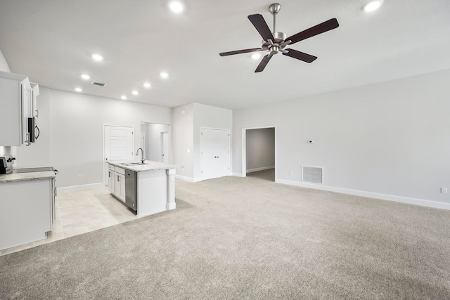 unfurnished living room featuring ceiling fan, sink, and light carpet