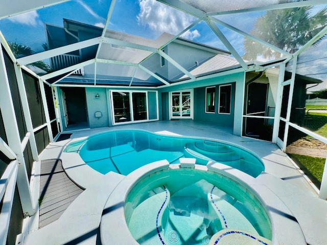 view of swimming pool featuring glass enclosure and an in ground hot tub