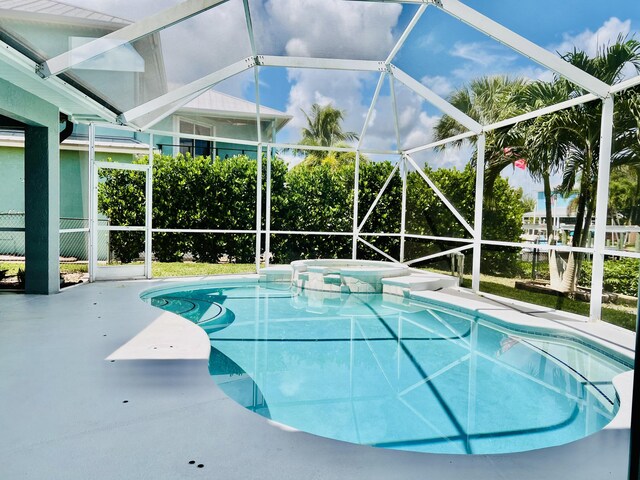 view of pool with a lanai, a patio, and an in ground hot tub