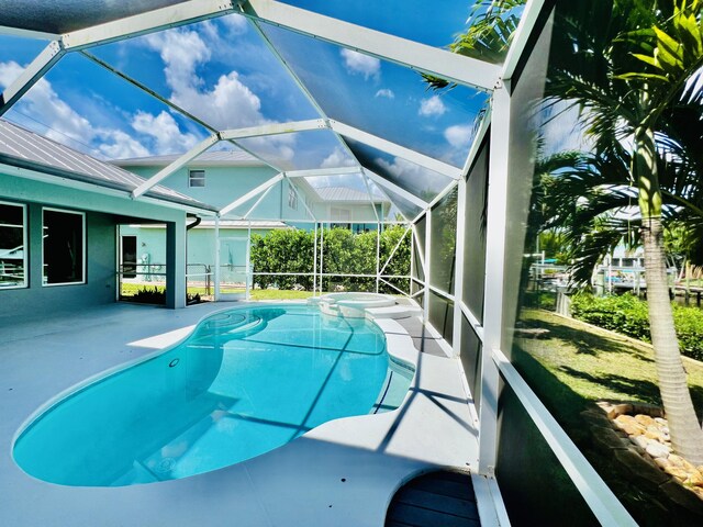 view of swimming pool featuring glass enclosure and a patio