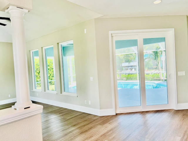 doorway featuring light hardwood / wood-style floors and decorative columns