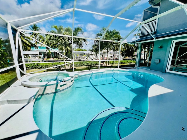 view of swimming pool featuring an in ground hot tub and a lanai