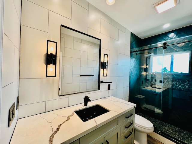 bathroom featuring toilet, a shower with door, and vanity