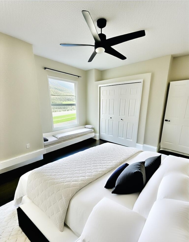 bedroom featuring ceiling fan, a textured ceiling, hardwood / wood-style flooring, and a closet