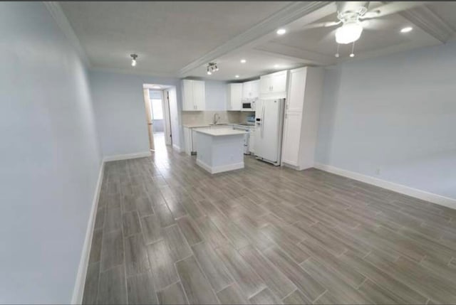 kitchen with white cabinetry, white appliances, a kitchen island, wood-type flooring, and ceiling fan