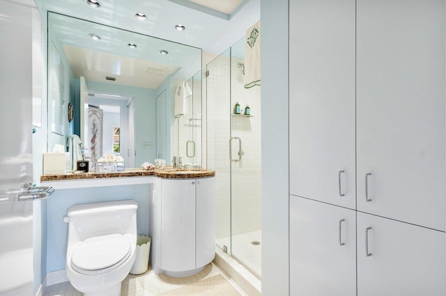 bathroom with tile patterned flooring, a shower stall, and toilet