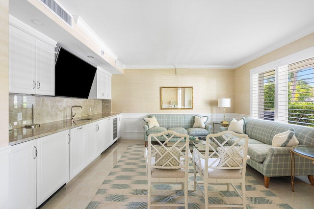 living room with sink, crown molding, light tile patterned flooring, and wine cooler