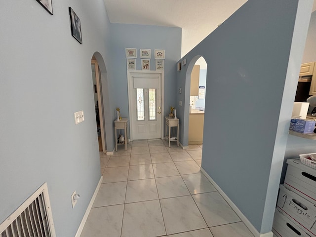 tiled foyer with a towering ceiling