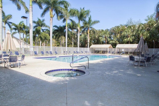 view of swimming pool with a hot tub and a patio