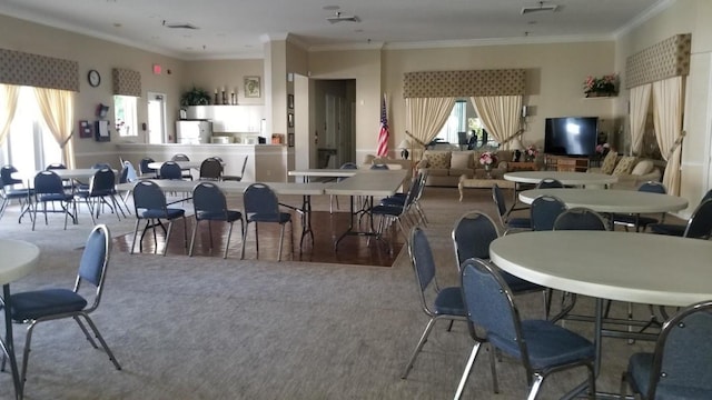 carpeted dining room featuring ornamental molding