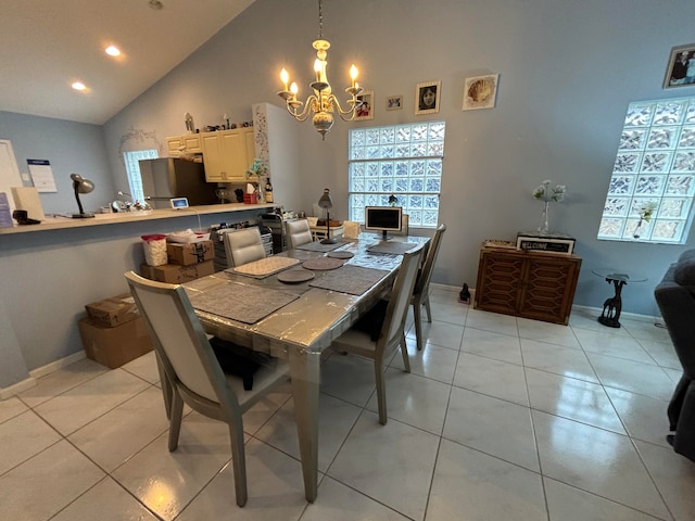 dining room featuring a notable chandelier, high vaulted ceiling, light tile patterned floors, and a wealth of natural light