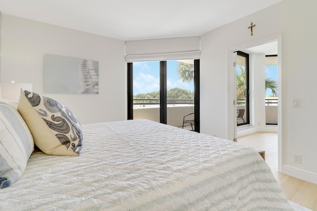 bedroom with access to exterior and light hardwood / wood-style flooring