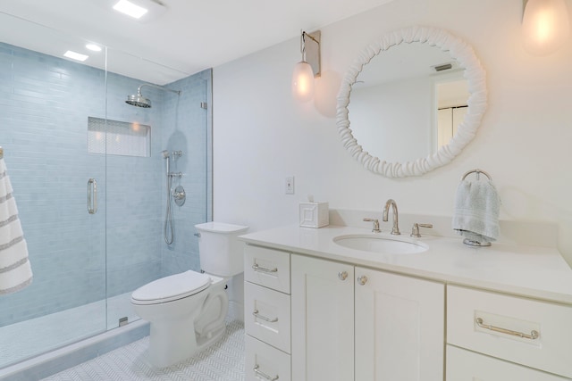 bathroom featuring vanity, toilet, a shower with shower door, and tile patterned floors