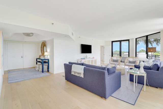 living room featuring a wall of windows and light hardwood / wood-style flooring