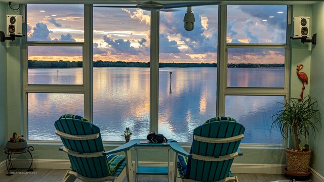 interior space with a water view, ceiling fan, and light hardwood / wood-style flooring