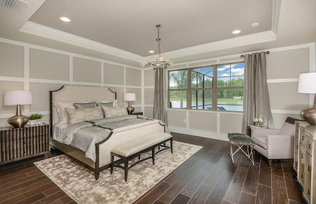 bedroom featuring dark wood-style floors, a tray ceiling, visible vents, and a decorative wall