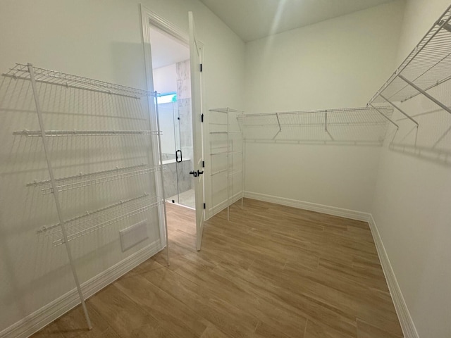 walk in closet with wood finished floors