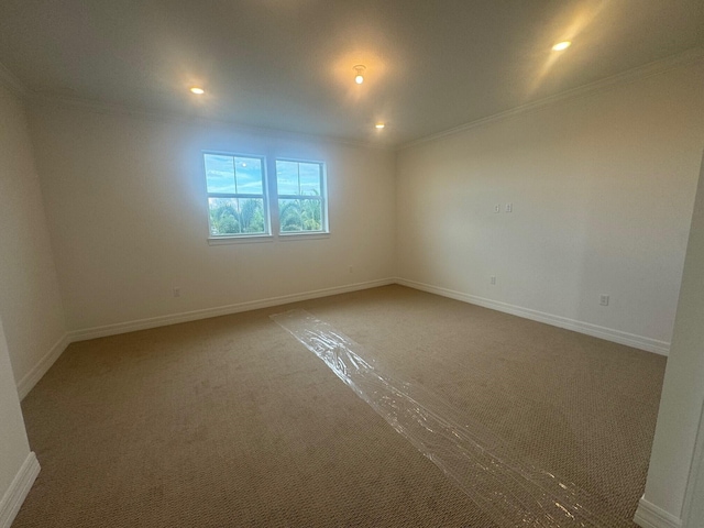 carpeted spare room featuring ornamental molding, recessed lighting, and baseboards