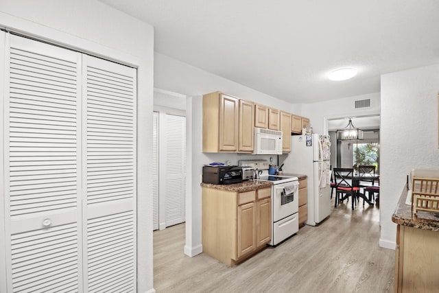 kitchen featuring light wood-type flooring, white appliances, light brown cabinets, and a notable chandelier