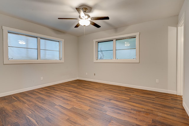 empty room featuring ceiling fan, dark wood-type flooring, and a healthy amount of sunlight