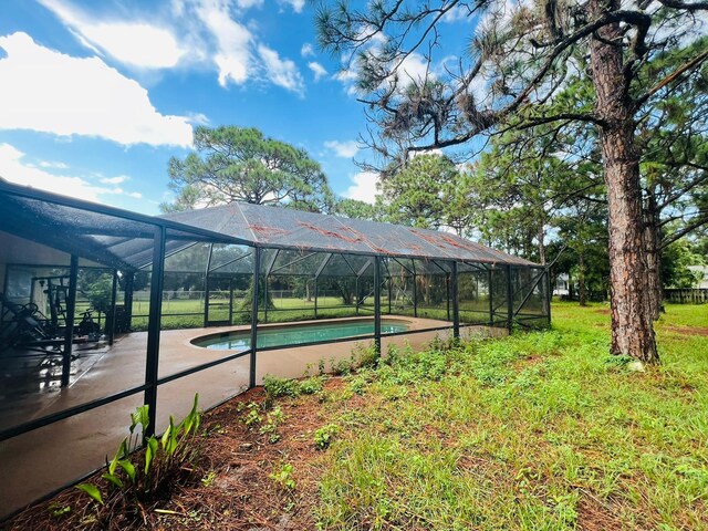 view of yard with glass enclosure and a storage unit