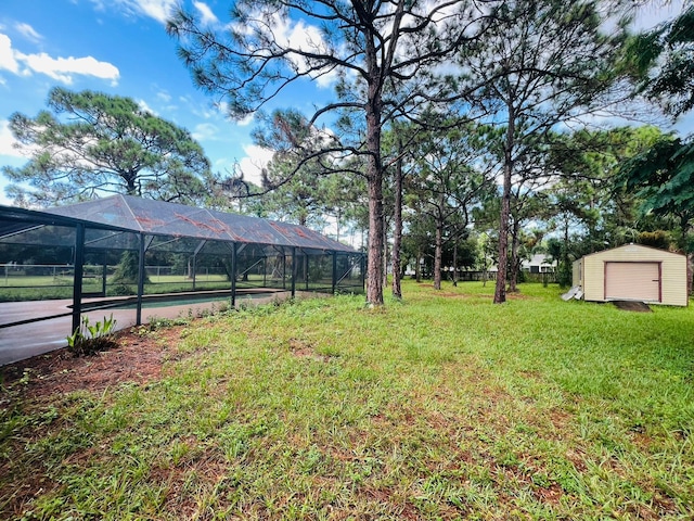 view of yard with a storage shed, a swimming pool, and glass enclosure