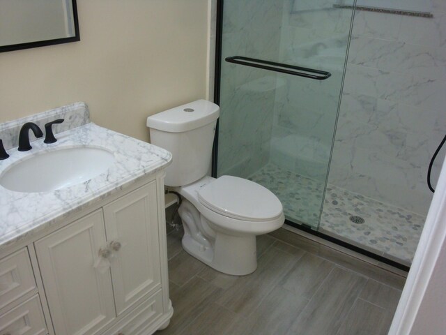 bathroom with toilet, walk in shower, and vanity