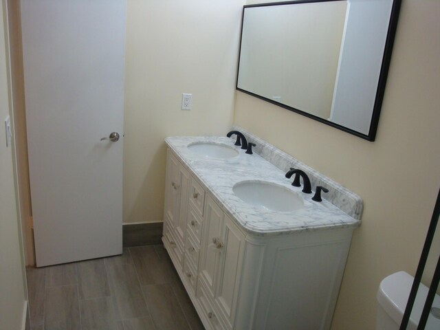 bathroom featuring toilet, vanity, and wood-type flooring