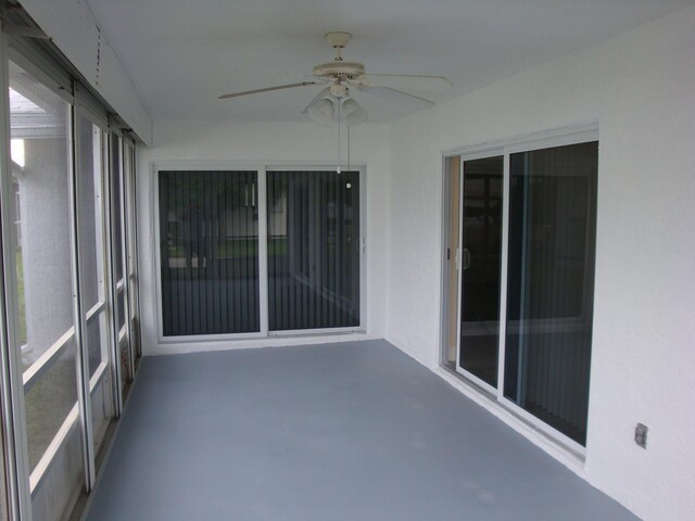 unfurnished sunroom with ceiling fan