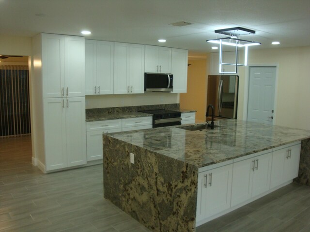 kitchen with appliances with stainless steel finishes, sink, and white cabinets